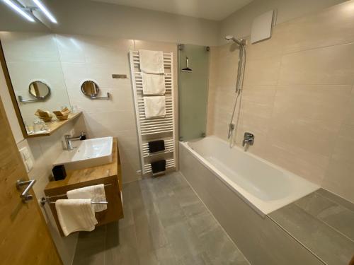 奥布施泰希Alpenperle的带浴缸、水槽和淋浴的浴室