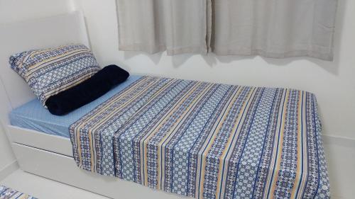 保罗阿方索城Condomínio Residencial Tranquilidade na Beira do Rio的卧室内的一张床铺,配有蓝色和白色床垫