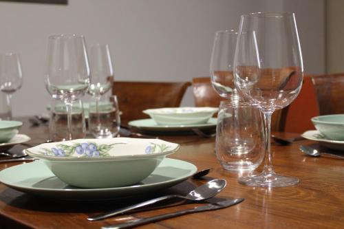 奥利文萨Casa Rialto的木桌,上面放着碗和酒杯