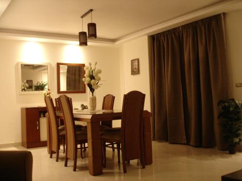 开罗Luxury Furnished Apartment的餐桌、椅子和花瓶