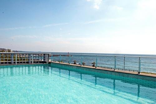 西归浦市日月度假酒店的一座背景海洋的游泳池
