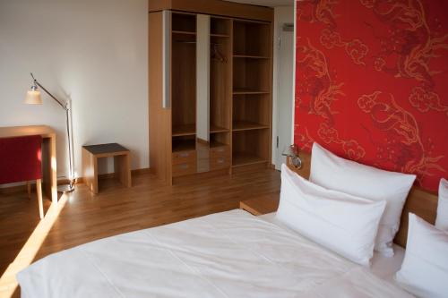 伍珀塔尔Gästehaus Auf dem Heiligen Berg B&B的卧室配有白色的床和红色的墙壁