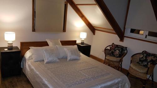 贝尔欧布莱天际线景观公寓的一间卧室配有一张带两盏灯和两把椅子的床。