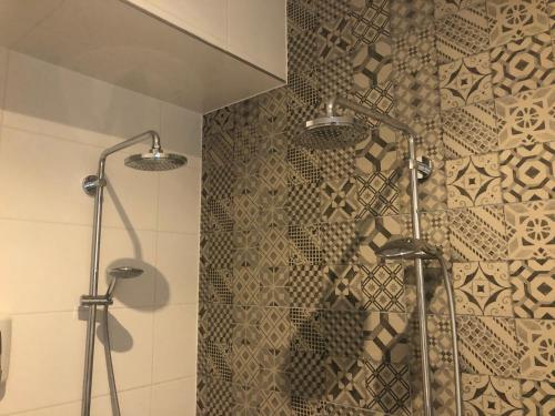赖斯韦克Hotel Hoevevoorde的带淋浴的浴室(带瓷砖墙)