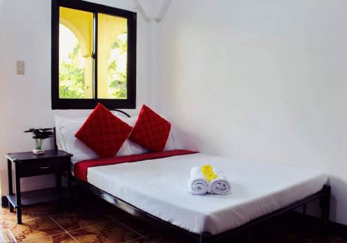 科隆Angel Gabriel Homestay的客房配有带红色枕头的床和窗户。