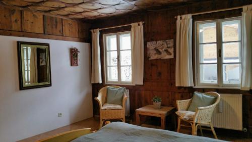 维尔德科格尔山麓布兰贝格Villa Zeppelin - App Bergkristall的一间卧室配有两把椅子和一张床,设有窗户。