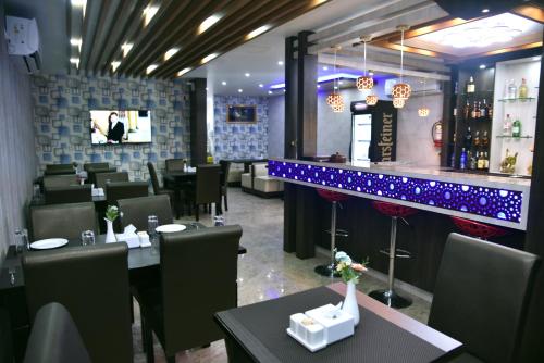 加德满都Marinha Airport Hotel的一间带桌椅的餐厅和一间酒吧