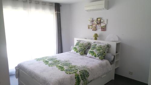 MontacherVilla Dikaria的白色卧室配有带绿色枕头的床