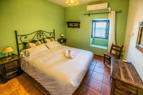 Pozo NegroTito´s Beach House的一间设有一张大床的卧室,位于带绿色墙壁的房间