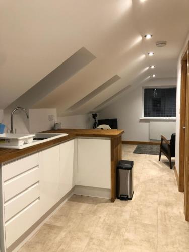杜伦quiet secluded loft in County Durham的阁楼厨房配有白色橱柜和水槽