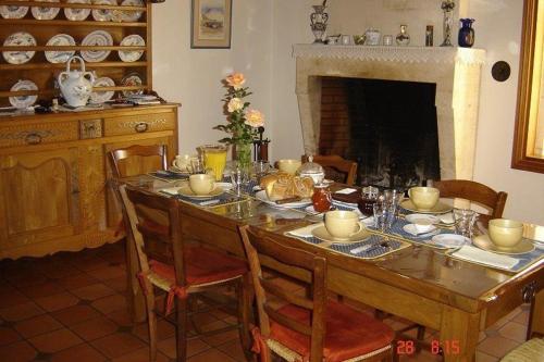 Saint-PorchaireChambres d'Hôtes Domaine Le Fragnaud的一间带桌子和壁炉的用餐室