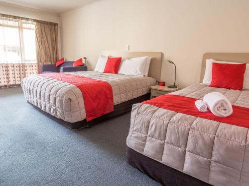 杰拉尔丁阿苏尔风景线汽车旅馆的一间卧室配有两张红色和白色床单