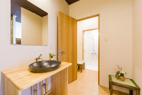 静冈Tessen Guesthouse的木制柜台上带水槽的浴室