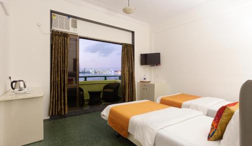 孟买南海绿色酒店 的酒店客房设有两张床和窗户。