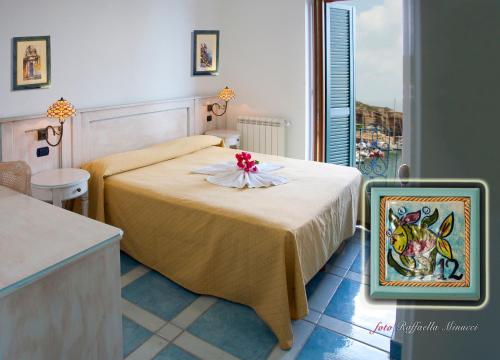 文托泰内Hotel Isolabella的一间卧室,配有一张带鲜花的床