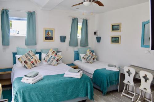 普利登堡湾The Green Palm Cottage的蓝色和白色的客房内的两张床