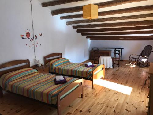 AdzanetaMasia Rural Canalisos的客房设有两张床,铺有木地板。
