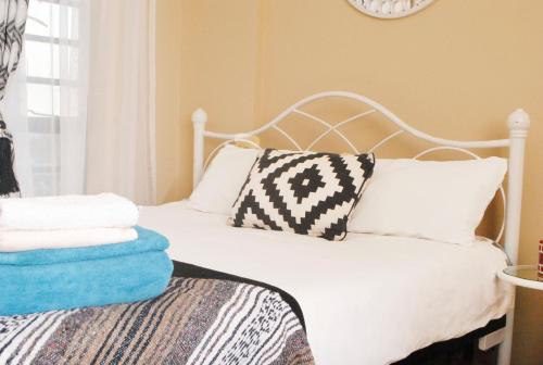 内罗毕WEST SUITES SHERRY HOMES的一张白色的床,上面有枕头