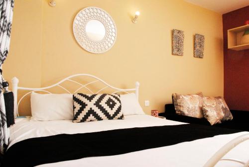 内罗毕WEST SUITES SHERRY HOMES的卧室配有白色的床和镜子