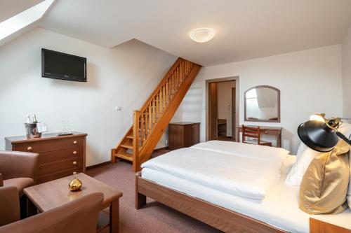 MístoPytloun Wellness Hotel Hasištejn的一间酒店客房,设有一张床和一个楼梯