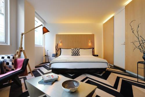 墨尔本阿德菲酒店的一间卧室配有一张床、一张桌子和一张沙发