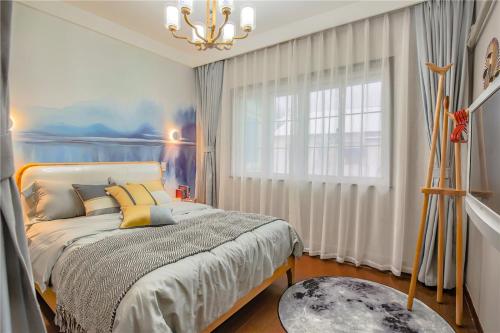 杭州【路客】杭州市上城区西湖·路客精品民宿·00144510的一间卧室设有一张床、一个窗户和一个吊灯。