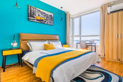 青岛【路客】青岛市黄岛区·青岛银沙滩风景区·路客精品公寓·00146300的一间卧室设有蓝色的墙壁和一张黄色毯子