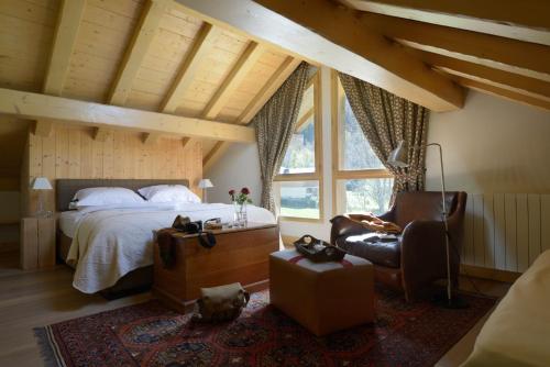 夏蒙尼-勃朗峰蒂索兹木屋酒店的一间卧室配有一张床和一把椅子