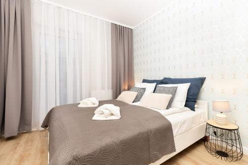 格但斯克Apartments Gdańsk Kochanowskiego by Renters的一间卧室配有一张大床和毛巾