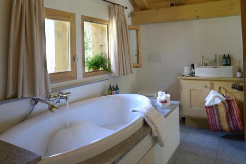 夏蒙尼-勃朗峰蒂索兹木屋酒店的带窗户的浴室内的白色浴缸
