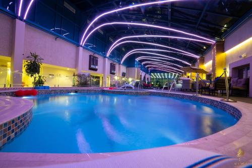 吉达卡萨布兰卡格兰德酒店的紫色灯的酒店内大型游泳池