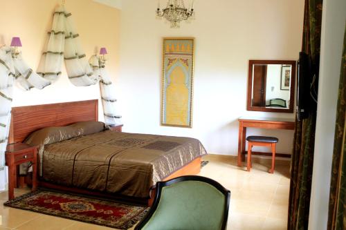 得土安里亚德达阿恰奇旅馆的一间卧室配有一张床、镜子和椅子