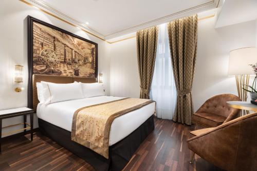 布拉格Áurea Legends by Eurostars Hotel Company的配有一张床和一把椅子的酒店客房