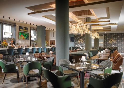邓多克Fairways Hotel Dundalk的一间带桌椅的餐厅和一间酒吧
