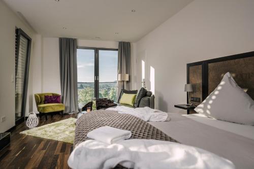KörperichBoutiquehotel Genusswerk Eifel的酒店客房设有一张床和一个大窗户