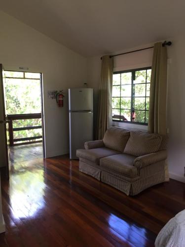 Santa ElenaSanta Cruz Cabins的带沙发和冰箱的客厅