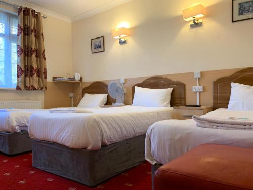 特威克纳姆图维克汉姆宾馆的酒店客房设有两张床和窗户。