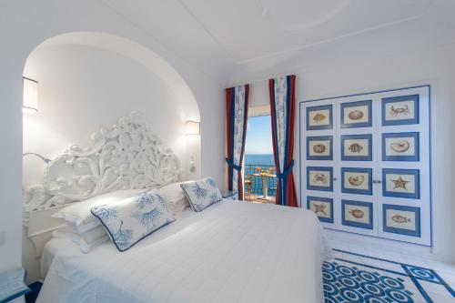 普莱伊亚诺昂达维尔得酒店的白色的卧室设有白色的床和窗户。