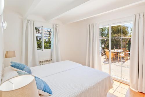马略卡岛帕尔马Villa Bellver的一间白色卧室,配有床和庭院
