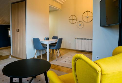 德瓦NORDIC Home的客厅配有黄色的沙发、桌子和椅子