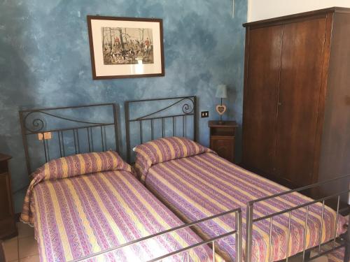 CasteggioIl Biancospino的卧室配有两张床,墙上挂着一幅画