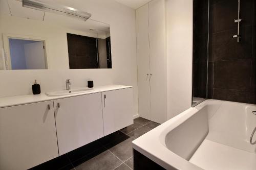 布鲁塞尔Rent a flat - Montgomery的浴室设有白色浴缸、水槽和浴缸。