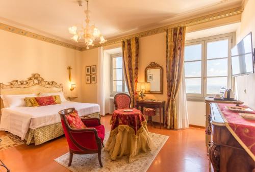 科尔托纳Hotel Villa Marsili的卧室配有一张床和一张桌子及椅子