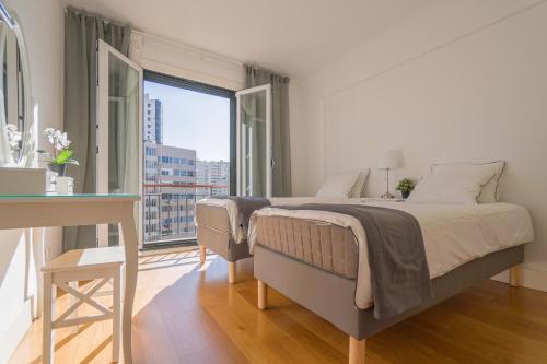 里斯本Lisbon Best Places - Rooftop的一间卧室设有一张床和一个大窗户