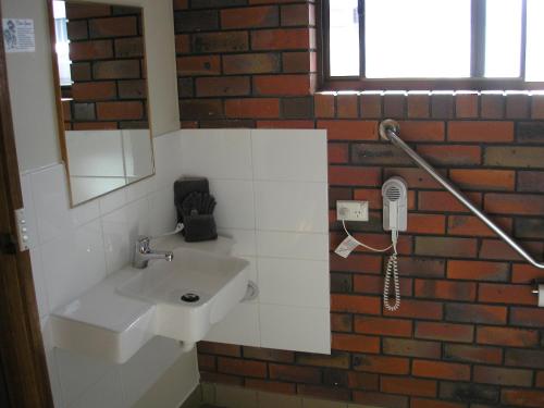 斯托尔克拉宾汽车旅馆的一间带白色水槽和砖墙的浴室