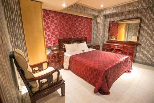 台北百悅旅社的一间卧室配有一张床、一把椅子和镜子