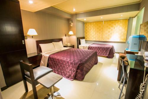 台北百悅旅社的酒店客房,配有两张床和椅子