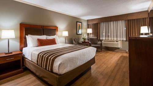 渥太华渥太华市中心贝斯特韦斯特酒店的酒店客房设有一张大床和一张书桌。