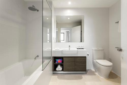 珀斯Quest Joondalup的一间带水槽、卫生间和镜子的浴室