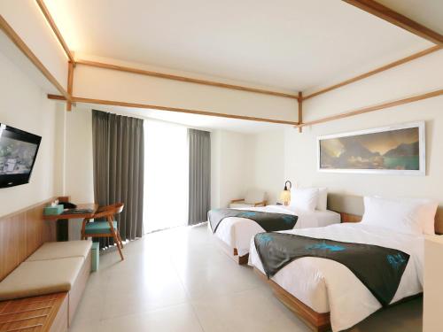 外南梦伊利拉班于万吉酒店的酒店客房设有两张床和电视。